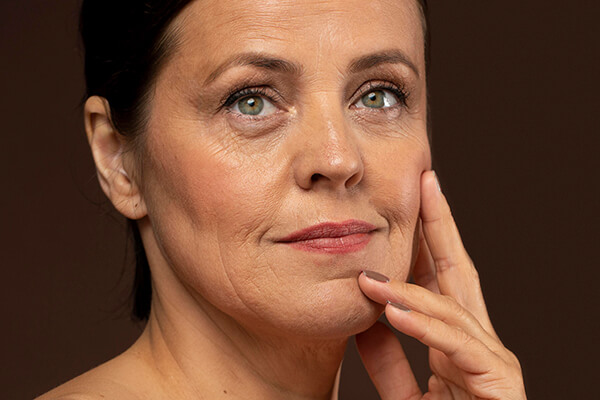 older woman touching face