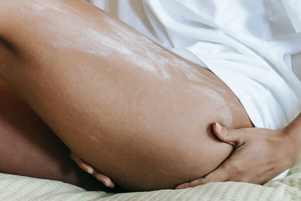 woman applying cream on legs